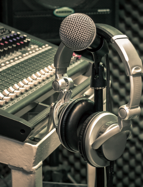 Unlock Your Musical Potential with The 4Ms Professional microphone and headphones in a recording studio, symbolizing music creation and the resources available at The 4Ms.